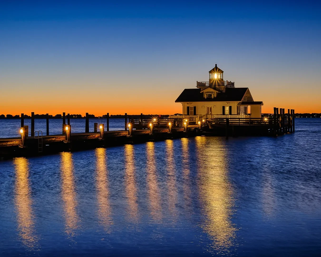 Roanoke Marshes Lighthouse at sunset with golden reflections