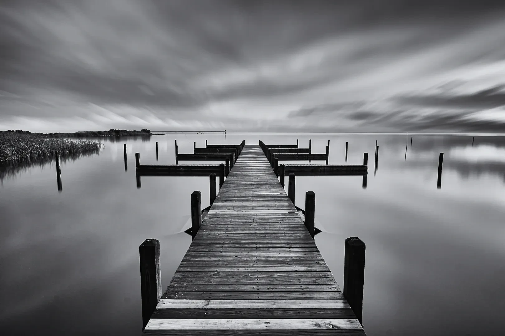 Black and white dock with dramatic long-exposure storm clouds