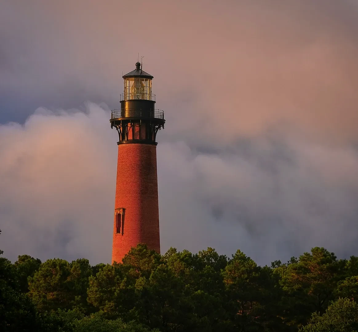 Currituck Beach Lighthouse glowing red at golden hour